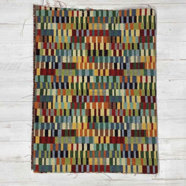 Retal de tela de tapicería gobelino estampado de rectángulos pequeños de colores.